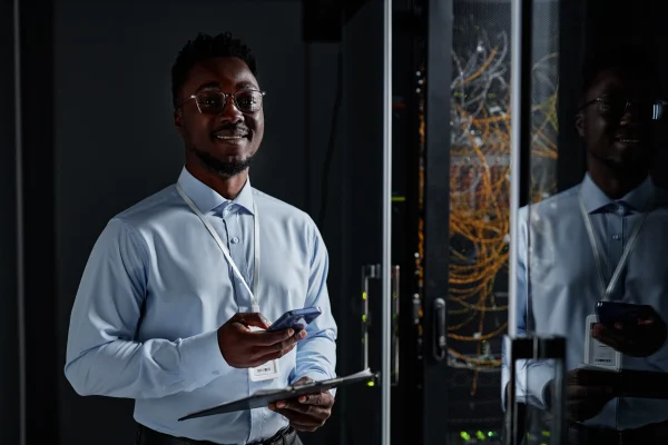 Smiling network engineer standing by server cabine 2025 03 10 05 53 30 utc